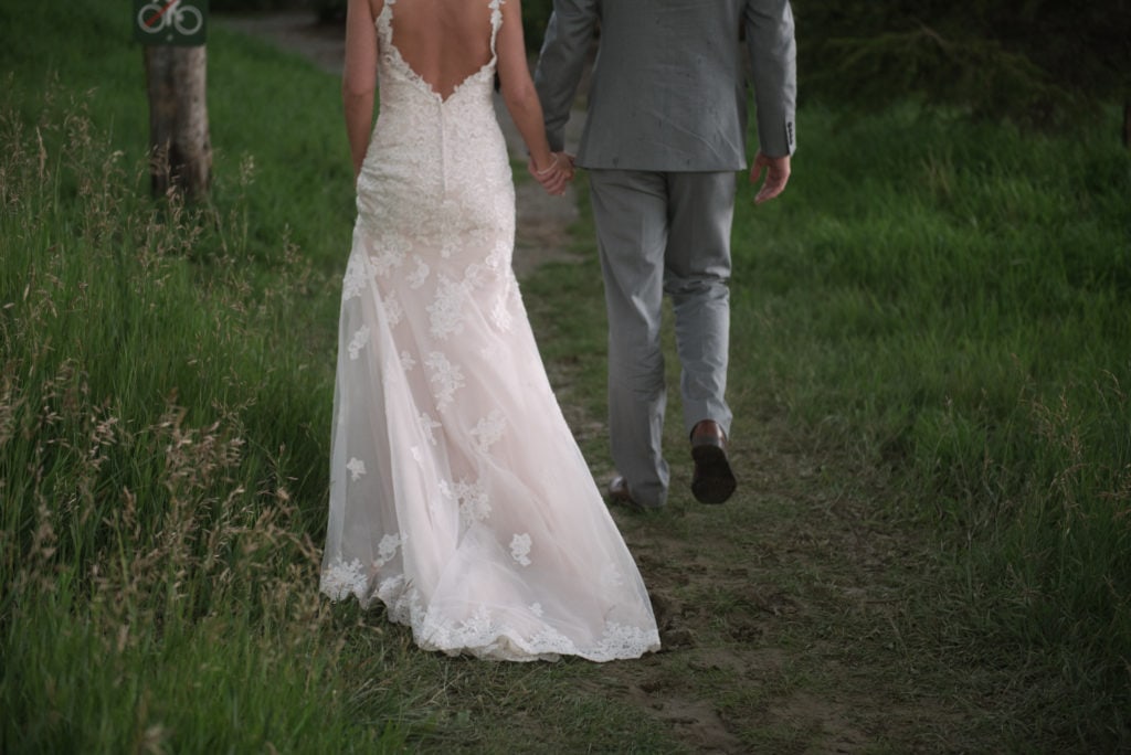 a year in review bride and groom walk hand in hand back to reception 