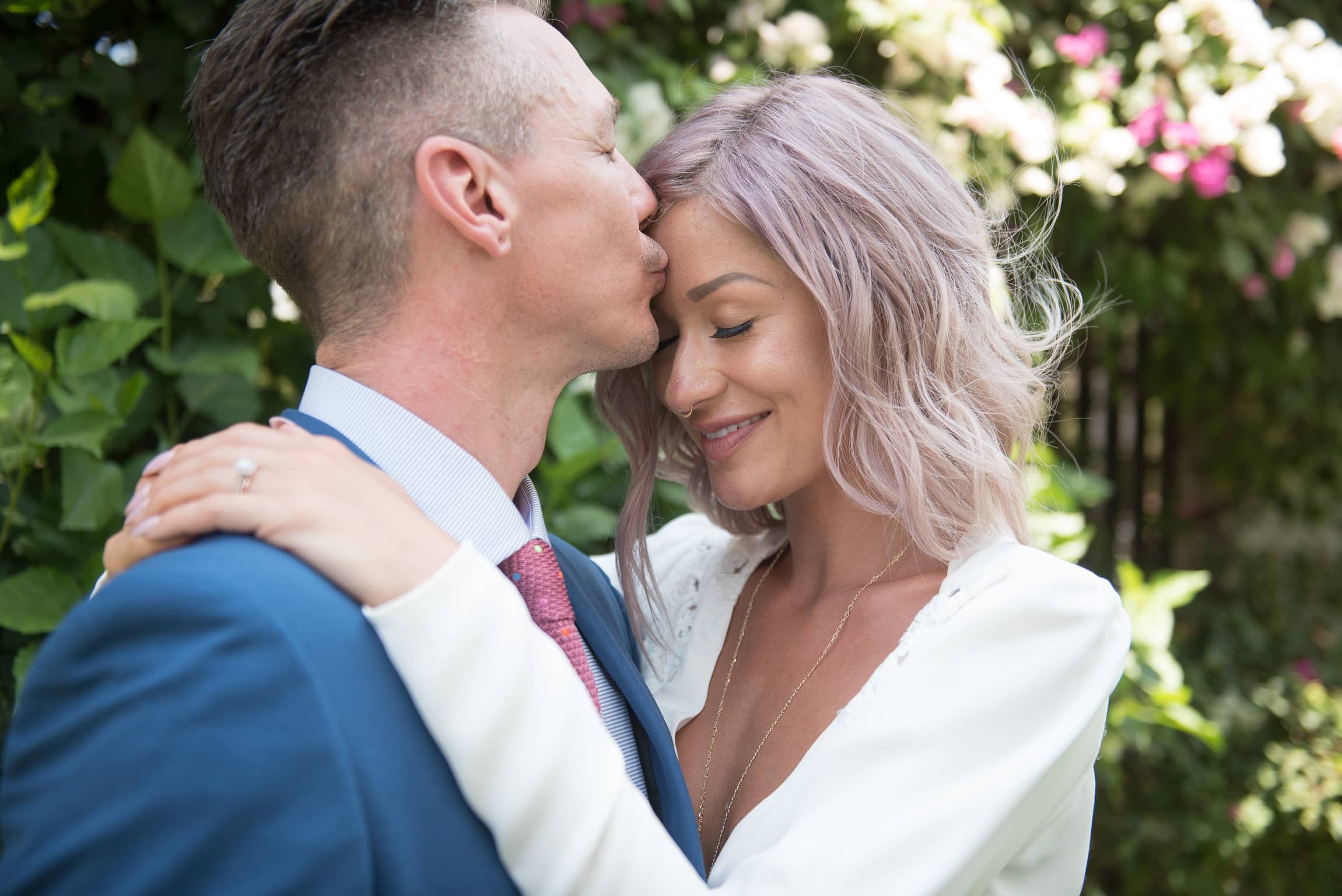 Groom kisses bride on the forehead