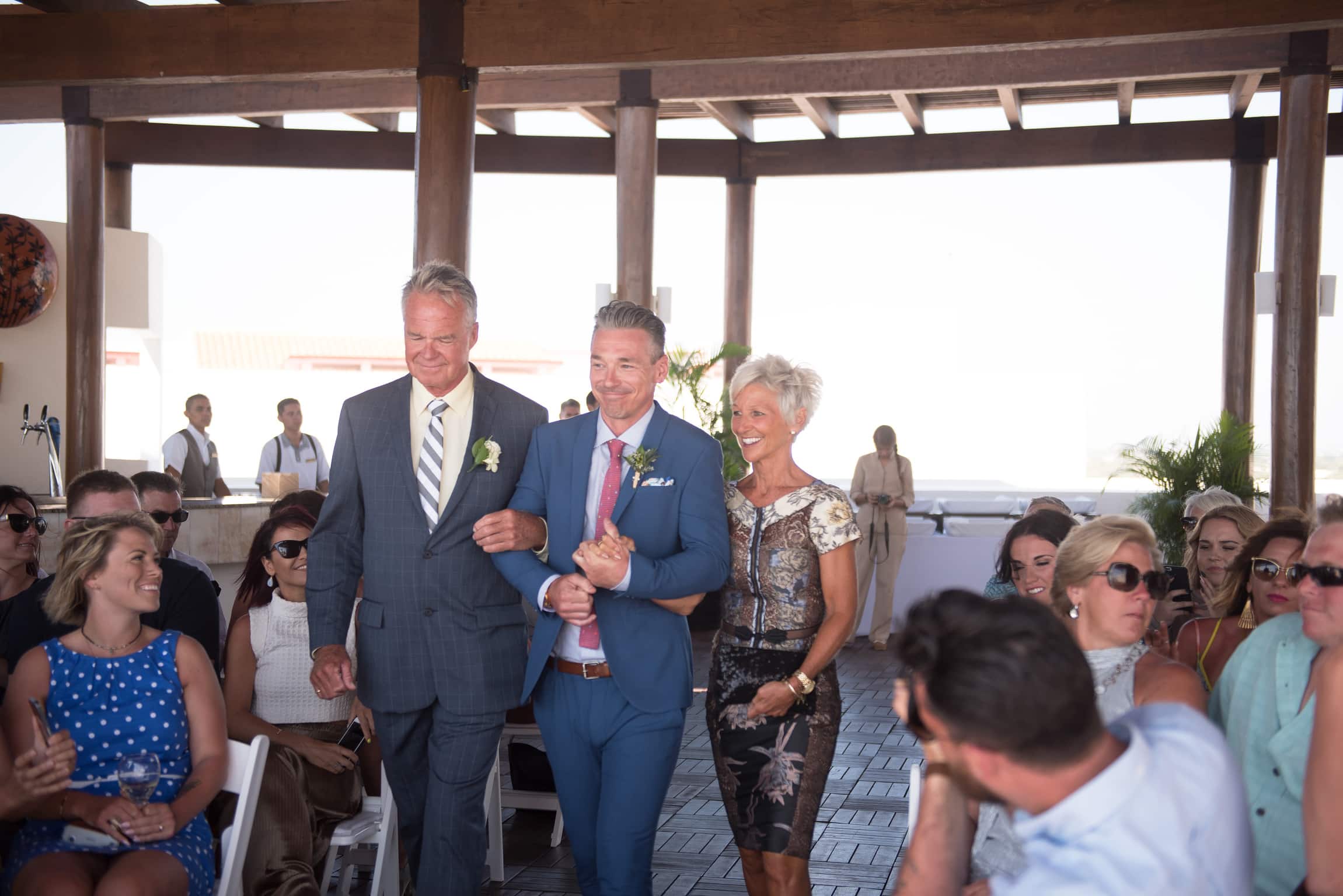 groom coming down aisle with parents