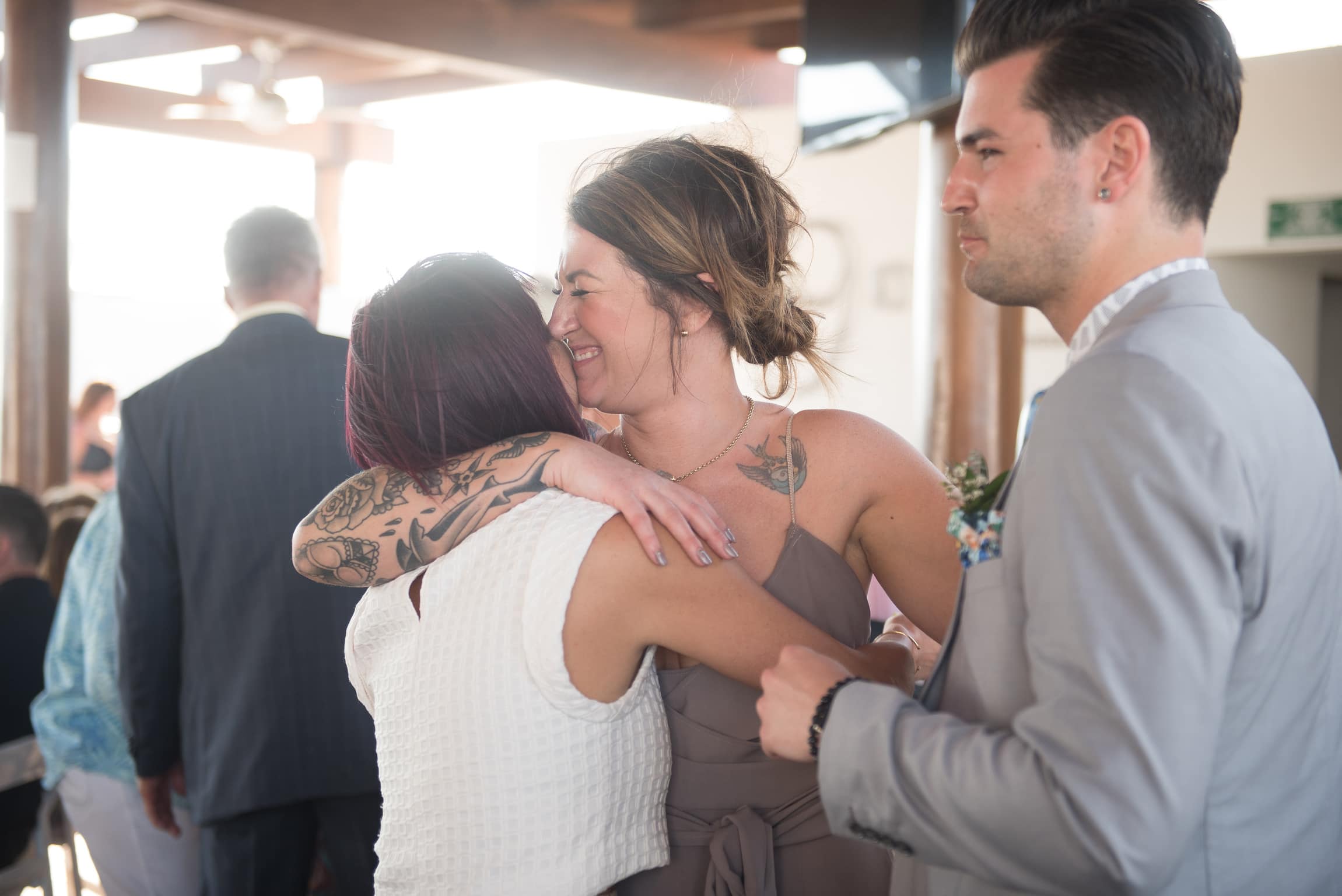 Sister of the groom hugs cousin