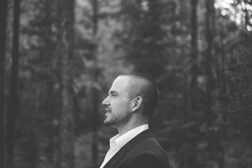 Side Profile of handsome groom looking off into forest