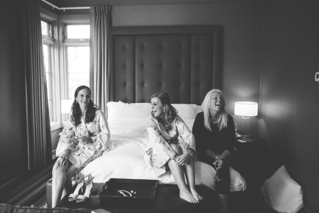a year in review bridesmaids and mother of the bride share a laugh on the bed 