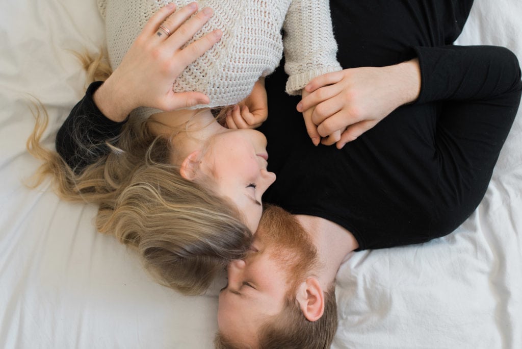 Intimate in home session couple lying down on bed